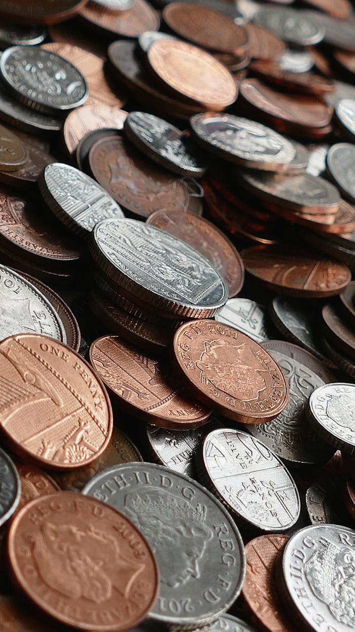 Close-up of various international coins in a pile, showcasing different currencies and designs.